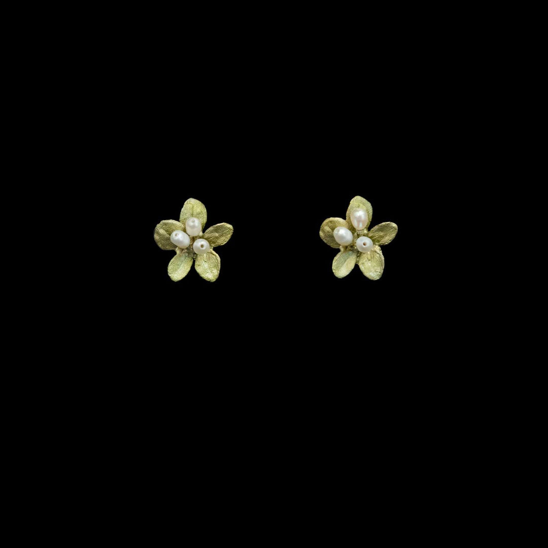 Ein Paar kleine blumenförmige Ohrstecker in strukturiertem Grün mit weißen Perlenzentren.