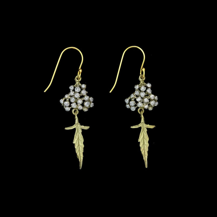 Pair of green leaf and crystal dust dotted earrings on a black background